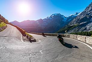 Motorrijders op een bergweg in de zon